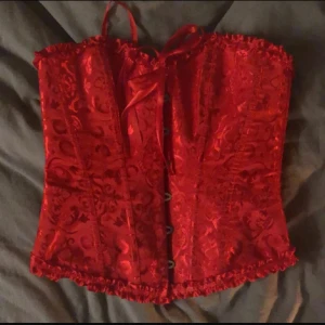 Röd korsett med snörning och spets - Säljer denna röda korsett i storlek m men jag har sytt in den så den passar en xs/s också så om man vill ha den i m är det bara att spreta upp stygnen💗 som ny använd 1 gång