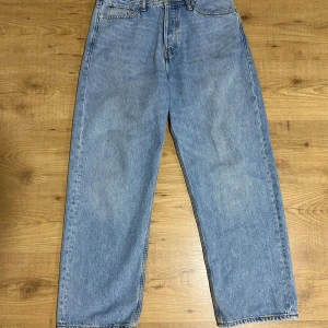 Baggy jeans från Jack & Jones - Baggy fit jeans från Jack & Jones i klassisk ljusblå denim. Byxorna har raka ben, femficksmodell och tydliga kontrastsömmar. Perfekta för dig som gillar en avslappnad och trendig look.