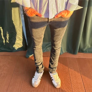 Mörkgrå skinny jeans herr - Snygga mörkgrå jeans med skinny passform och klassisk femficksdesign. Jeansen har en smal siluett som sitter tight längs benen och är perfekta för en modern och avslappnad stil. Passar dig som gillar en stilren look med lite edge.