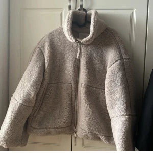 Beige pilejacka  - Mysig beige teddyjacka med hög krage och två stora fickor framtill. Perfekt för kyliga dagar när du vill vara både varm och snygg💕💕