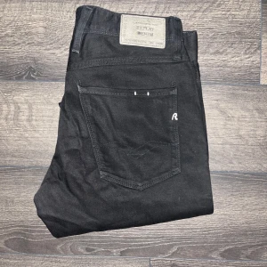 Svarta Replay Anbass jeans - Säljer ett par svarta Replay Anbass jeans i storlek 31. Jeansen har klassisk femficksdesign, raka ben och snygga detaljer med Replay-logga på bakfickan. Modellappen är borta men modellen är Anbass ! Midja 43cm, längd 94cm. Det är möjligt att jeansen är uppsydda då jag tycker dem är lite korta, och kanske är mer som L30 så kolla måtten noggrant ! JAG SKICKAR INGA FLER BILDER NÄR JAG BÄR JEANSEN :) (S2)