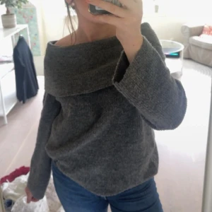 Grå offshoulder stickad tröja H&M - Mysig grå stickad tröja från H&M med bred offshoulder-krage och långa ärmar. Perfekt för dig som gillar en chill och snygg look. Tröjan har en loose passform och är superenkel att styla.