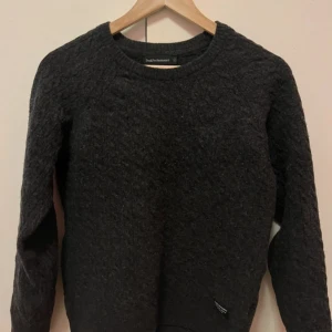 Mörkgrå stickad tröja Peak Performance - Mysig mörkgrå stickad tröja från Peak Performance i fin lammull. 