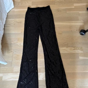 Svarta paljettbyxor från Lindex - Svarta byxor från Lindex i storlek 164, täckta med glittrande paljetter för en riktigt snygg look. Byxorna har rak passform och resår i midjan för extra komfort. Perfekta när du vill sticka ut och glänsa lite extra. Använda max 2 gånger. Pris går att diskutera 💗