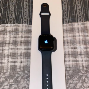 Apple Watch svart aluminium: HELT NY ÄKTA - Säljer en stilren Apple Watch med svart aluminiumboett och svart silikonarmband. Klockan har en fyrkantig form och digital display. Perfekt för dig som vill ha koll på notiser, träning och hälsa direkt på : SAMMA DAG DU KÖPER SAMMA DAG JAG FRAKTR
