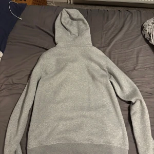 Ljusgrå hoodie från Sail Racing XL - Snygg ljusgrå hoodie från Sail Racing i storlek XL. Tröjan har hel dragkedja, huva med snörning och en bröstficka med Sail Racing-logga. Tillverkad i mjuk bomull, perfekt för chill dagar eller när du vill ha en clean look. Den passar även L. Priset är diskuterbart!