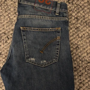 Dondup jeans - Säljer ett par blå Dondup jeans med snygga slitningar. Jeansen har en slim fit passform. Väldigt fint skick, priset är ej hugget i sten