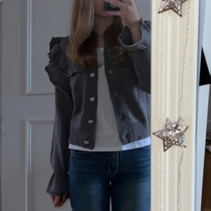 Kofta med volang  - Grå Kofta med volang storlek S 