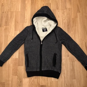 Stickad cardigan - Riktigt stilig stickad cardigan med fleece inuti perfekt inför de kallare dagarna. Storlek S, inga defekter förekommer. För mer frågor eller funderingar är det bara att höra av sig!