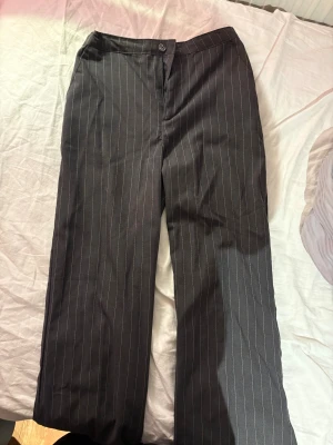 Grå randiga kostymbyxor - Säljer ett bar knappt använda grå vit randiga kostymbyxor i st 152 ifrån HM men funkar säkert som XXS, kan skicka midjemått om de önskas💓säljer för att de är för små för mig