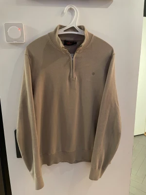 Morris Beige quarter-zip tröja - Väldigt fin beige långärmad tröja från Morris, modell Riley Half Zip, i storlek M. Tröjan  är tillverkad i 100% pima bomull för extra mjuk känsla. Diskret Morris-logga broderad på bröstet. Säljes eftersom den är för liten. Knappt använd. Priset kan diskuteras vid snabb affär. Tveka inte att höra av er vid frågor!