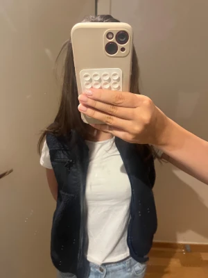 Teddy/ fleece väst  - Mysig svart fleeceväst med hel dragkedja framtill och praktisk ficka med dragkedja på bröstet. Västen har en enkel, stilren design och är perfekt att slänga över en t-shirt eller hoodie. Materialet är mjukt och värmande, och insidan har ett slätt tyg för extra komfort.