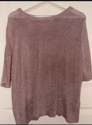 Glittrig topp från Carin Wester - Säljer en glittrig topp från Carin Wester i storlek L. Tröjan har en lös passform, trekvartsärm och är stickad i ett skimrande material med metallic-effekt. Perfekt för dig som vill sticka ut med en cool och trendig look.