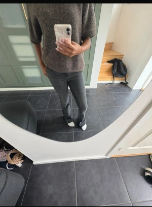 Grå bootcut jeans med låg midja - Säljer ett par grå jeans med snygg bootcut och låg midja. Jeansen har klassisk femficksdesign, dragkedja och knapp framtill. Materialet är jeans med en lätt tvättad look och passformen är normal med lite utsvängda ben.