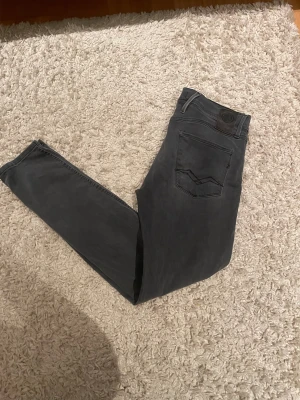 Replay Anbass  jeans - Snygga mörkgrå Replay Anbass jeans med slim passform och distresses look. Väldigt bra skicka på jeansen. Storlek 32w - 32l. 