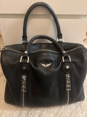 Zadig & Voltaire väska - Jag säljer min Zadig väska i modellen M. Det är den större varianten som rymmer väldigt mycket. Jag köpte den från Jackie för några månader sen men använder den knappt och vill därför sälja. Jag har kvitto och axelband som tillbehör💞