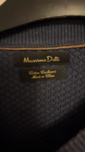 Blå stickad tröja Massimo Dutti - Snygg blå stickad tröja från Massimo Dutti i bomull och kashmir. Tröjan har rund hals, långärmade ärmar och ett diskret strukturerat mönster som ger en cool vibe. Perfekt för dig som gillar stilrena och bekväma plagg.