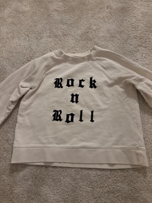 Vit tjocktröja från Zadig& voltare   - Säljer en vit sweatshirt från Zadig & Voltaire i storlek 16 med svart Rock n Roll-tryck på framsidan. Tröjan har rund hals, långa ärmar och är gjord i mjuk bomull. 