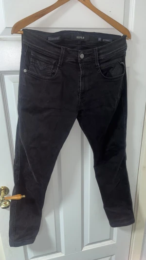 Replay Hyperflex Anbass svarta jeans - Tjo boss! Säljer mina svarta Replay  Anbass jeans med klassisk femficksdesign och smal passform. Stretchigt material för extra komfort och snygg siluett. Diskreta Replay-detaljer på fickorna och midjan. De är i mycket bra skick och används inte så ofta! Hör av dig om det är något!