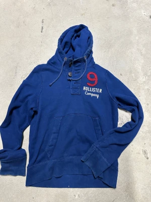 Vintage Hollister hoodie med knappar - Säljer nu denna extremt eftertraktade och sällsynta Vintage Hollister Hoodie med knappar! Grymt skick, inga defekter - ser exakt ut som på bilderna! Storlek M! Skriv gärna vid frågor 💬✌️