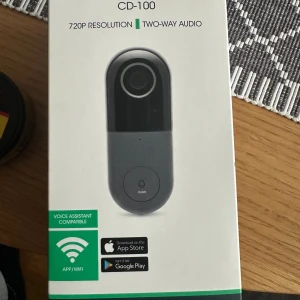 Cleverio CD-100 Smart Doorbell - Cleverio CD-100 är en smart dörrklocka med 720p video, tvåvägsljud, rörelse- och ljuddetektering samt nattseende. Stöd för appstyrning via WiFi, kompatibel med röstassistent. IP53-klassad, minneskort upp till 128GB. Produkten är ny i förpackning.