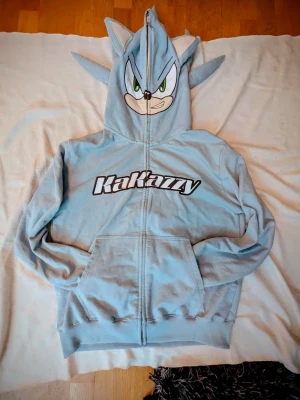 Kakazzy Hoodie (oanvänd) - Fick denna Hoodie på min födelsedag för ca 3 år sedan men har inte passat mig riktigt, så jag har aldrig använt den. Den är som ny och i jätte bra skick. Storlek L/Large för vuxna