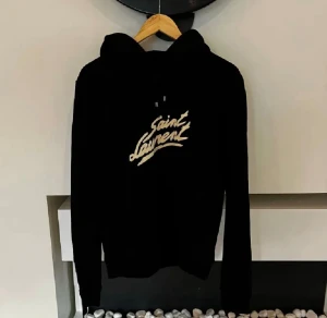 Yves Saint Laurent Hoodie  - Tjena, säljer denna helt nya, jättesnygga hoodien från Saint Laurent i den finaste modellen. På hoodien står det M, men den passar som S/M. Skriv gärna vid intresse!