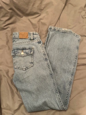Ljusblå jeans med fickor  - Ljusblåa lågmidjade bootcut jeans med fickor från Gina