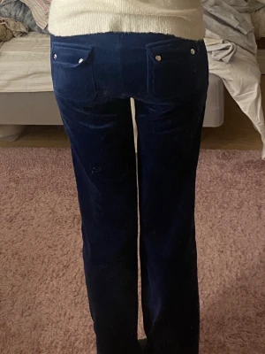 Mörkblåa juicy couture del rey byxor - Snygga mörkblå manchesterbyxor med raka ben och stora fickor både fram och bak, dekorerade med silverfärgade knappar. Byxorna har en klassisk passform och är perfekta för dig som gillar retrovibbar och mjuka material.