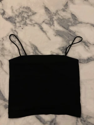 Svart linnetopp från Gina Tricot XXS - Svart, stilren linnetopp från Gina Tricot i storlek XXS. Toppen har smala axelband och en rak, croppad passform som ger en clean look. 