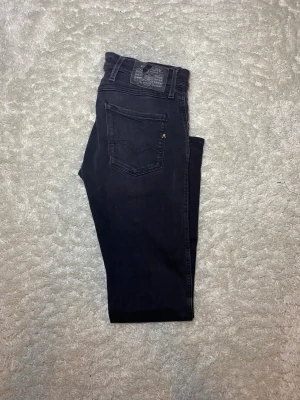 Svart Replay Anbass jeans - Skick 7,8/10, flärpen längst bak är sliten. |Storlek W30 L32| Modell Anbass vilket är slimfit| Gåva ingår vid köp!