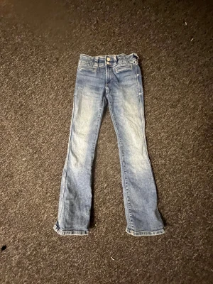 Bootcut Jeans från Hm - Blå Low waisted jeans från Hm använda Max 2 gånger. Byxorna är utsvängda där nere och fina detaljer på fickorna 