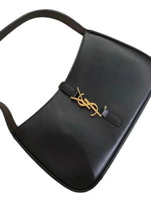 Svart axelväska från Yves Saint Laurent - Snygg svart axelväska från Yves Saint Laurent med guldigt YSL-emblem framtill. Väskan har en stilren, rektangulär form och justerbar axelrem. Tillverkad i slätt skinn med minimalistisk design och gulddetaljer som ger en lyxig vibe 😊    1a bild lånad