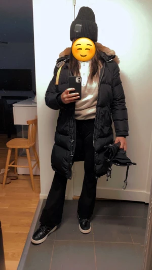 Svart lång dunjacka Parajumpers - Säljer en svart lång dunjacka från Parajumpers med stor fluffig huva med fuskpäls och snygga detaljer. Jackan har dragkedja, knappar och två stora fickor framtill. Perfekt för kalla vinterdagar och riktigt stilren look. Jag är personligen 36/38 & passar därför dig som är denna storlek :) den har dragkedja på varje sida om man vill öppna upp där som ”slits” eller om man väljer att ha den stängd. 