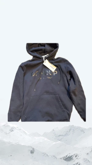 Dondup hoodie - Svart hoodie från Dondup med snyggt logotyptryck på bröstet. Klassisk modell med huva, snörning och stor känguruficka framtill. Tillverkad i mjuk bomull som känns skön mot huden. Storlek M. Ny skick 10/10 skick. Bara att skriva vid minsta fundering