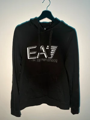 Emporio Armani hoodie svart - Emporio Armani hoodie i bra skick men texten i framsidan saknas lite, pm vid intresse.