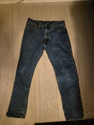Levi's 501 mörkblå jeans straight fit - Klassiska Levi's 501 jeans i mörkblått. Litet hål på ena benet (se bild)