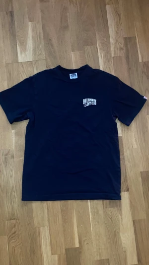 Navy Billionaire Boys Club t-shirt  - Navy t-shirt från Billionaire Boys Club i 100% bomull. Klassisk passform med korta ärmar och rund hals. Tryck med logga och astronaut på bröstet samt liten etikett med astronaut på sidan. Perfekt för dig som gillar streetwear och snygga basplagg. Vid fler frågor eller funderingar tveka inte på att skriva!