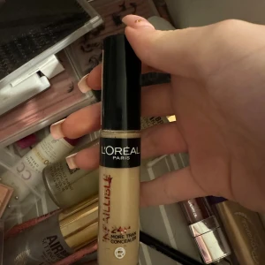 L'Oréal Infaillible Concealer 322 - Ljusbeige concealer från L'Oréal Paris, Infaillible More Than Concealer i nyansen 322 Neutral. Kommer i en smidig tub med svart lock och applikator. Perfekt för att täcka mörka ringar och ojämnheter med ett naturligt resultat.