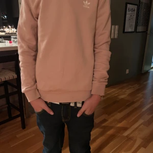 Beige sweatshirt från Adidas - Snygg beige sweatshirt från Adidas med klassisk liten logga på bröstet. Tröjan har rund hals, långa ärmar och ribbade muddar vid ärmslut och nederkant. Perfekt för chill dagar och enkel att matcha med jeans eller joggers. Aldrig använd. Så här sitter den på mig som är 160