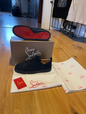 Mörkblå sneakers från Christian Louboutin - Säljer ett par riktigt snygga Christian Louboutin skor! Skorna är i mycket bra skick och har inga defekter. Allting på bilderna tillkommer. Om ni har några frågor så är de bara att höra av er😊