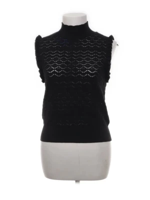 Svart ärmlös stickad topp med struktur - Säljer en svart ärmlös stickad topp med hög hals och snyggt strukturmönster. Toppen har volangdetaljer vid axlarna och ett diskret hålmönster som ger en cool look. Perfekt att styla med jeans eller kjol för en trendig outfit.