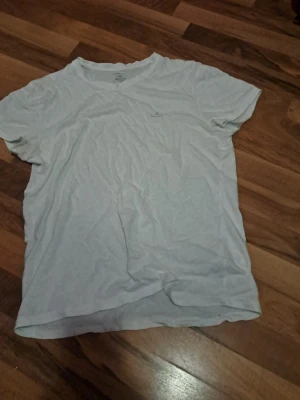 Vit t-shirt från GANT i bomull - Säljer en enkel och stilren vit t-shirt från GANT i storlek M. T-shirten har korta ärmar, rund hals och diskret GANT-logga på bröstet. Materialet är mjuk bomull som känns skönt mot huden. Perfekt för dig som gillar klassisk och clean stil. Pris kan diskuteras