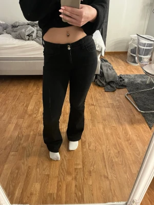 Svarta bootcut jeans från Gina Tricot - Svarta jeans från Gina. Väldigt snygga och dom sitter bra. Dom passar storlek 36-38 fast dom är i storlek 164. Dubbel knäppe fram och mönster på fickorna