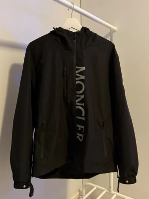 Moncler windbreaker - Säljer denna svarta moncler vindjackan, den är i storlek L men sitter som en M! Otroligt bra skick✅ Riktigt snygg och perfekt nu inför våren!☀️🍃
