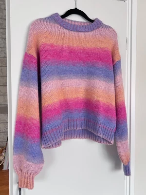 Randig stickad tröja från BikBok, storlek S - En loose fit stickad tröja från BikBok i storlek S med ränder i rosa, lila och orange. Ribbade muddar och haksringning. Knappt använd. - Köper du innan kl 16:00 kan jag posta samma dag!