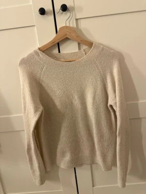Stickad tröja  - Mysig beige stickad tröja med rund halsringning och ribbade muddar vid ärmslut och nederkant. 