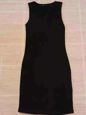 Svart ärmlös klänning  - Säljer en svart, tight och ärmlös klänning från Zara i storlek S. Klänningen är ribbad och har en enkel, rak design. Materialet är mjukt och stretchigt, vilket gör den bekväm att bära. !!endast swish +frakt!!