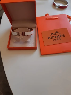 Hermes armband  - Bilderna visar ett Hermès-armband i originalask och påse, 