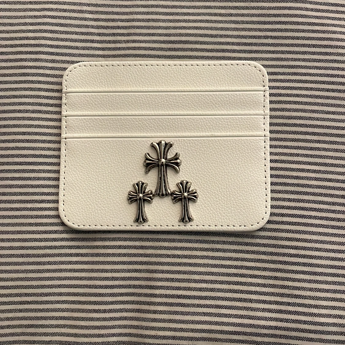 Vit plånbok med korsdetaljer